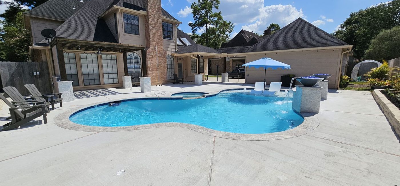 Completed resort-style pool with fire bowls and water features
