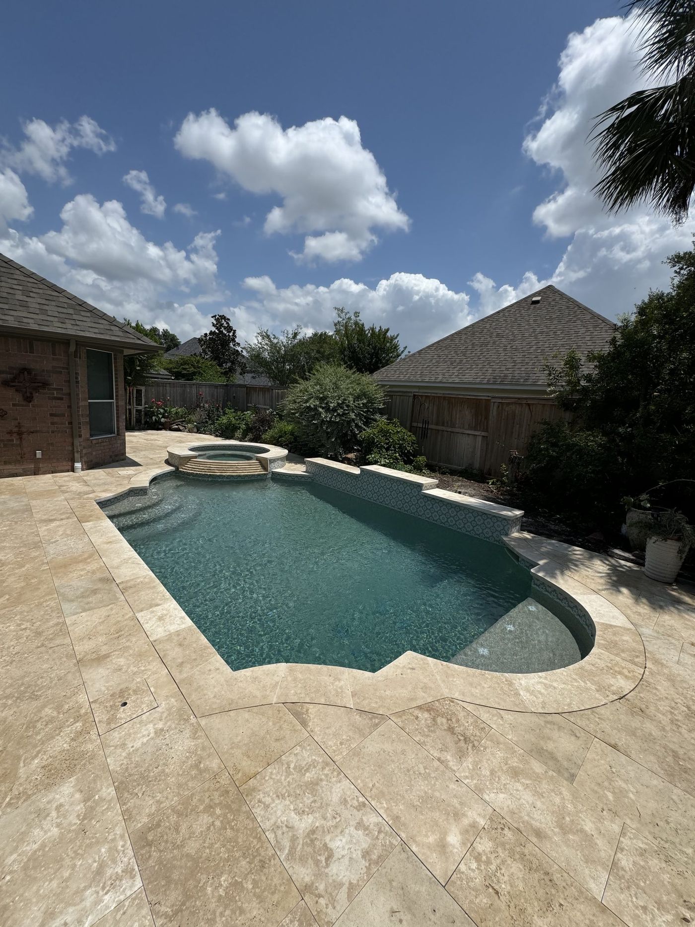 Finished travertine pool backyard