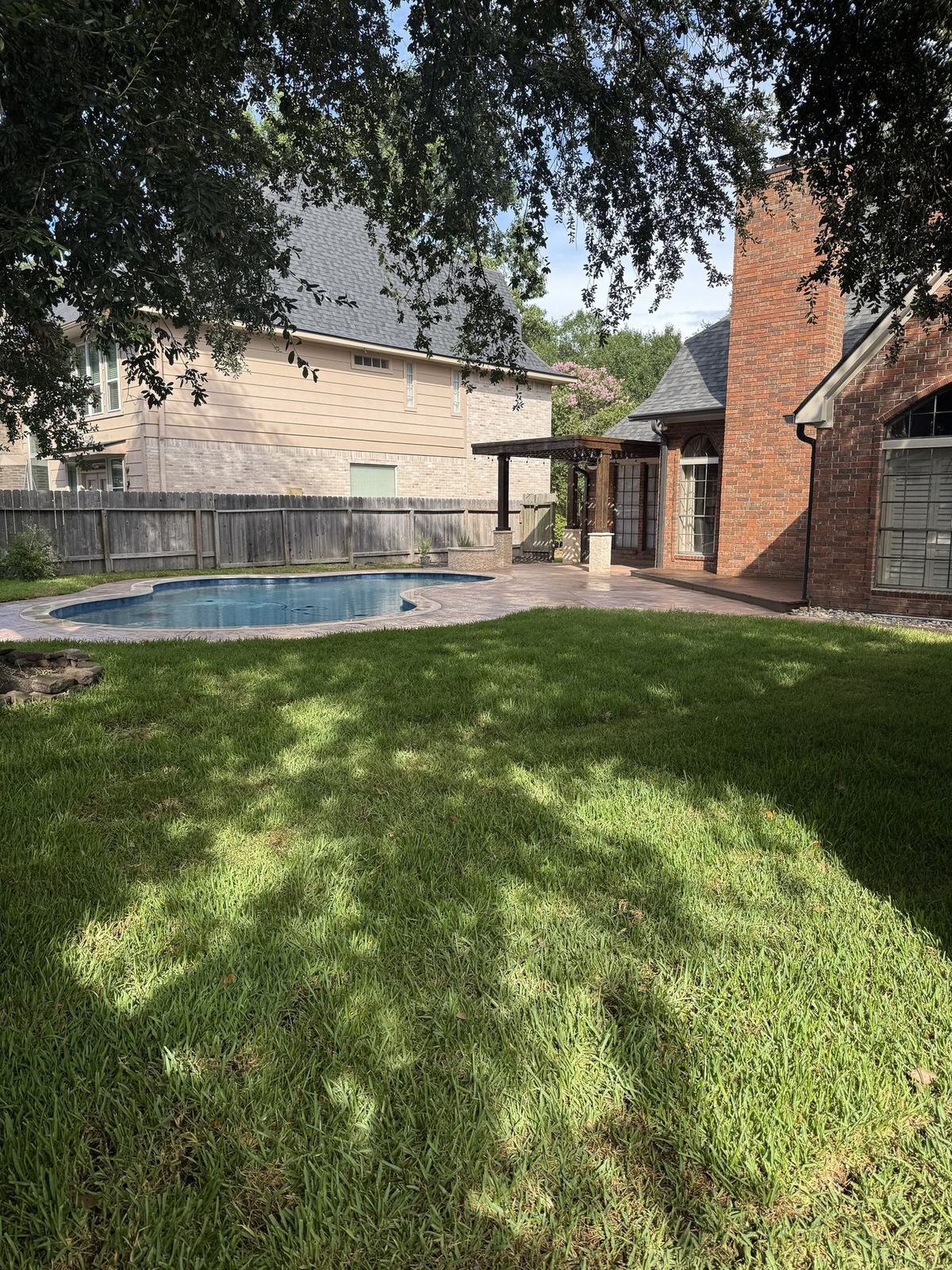 Finished pool with stamped concrete deck and pergola